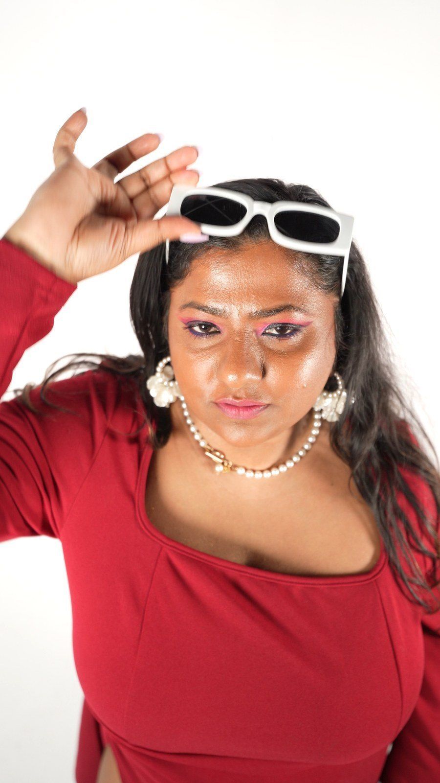Lakshmi in a red dress with white sunglasses