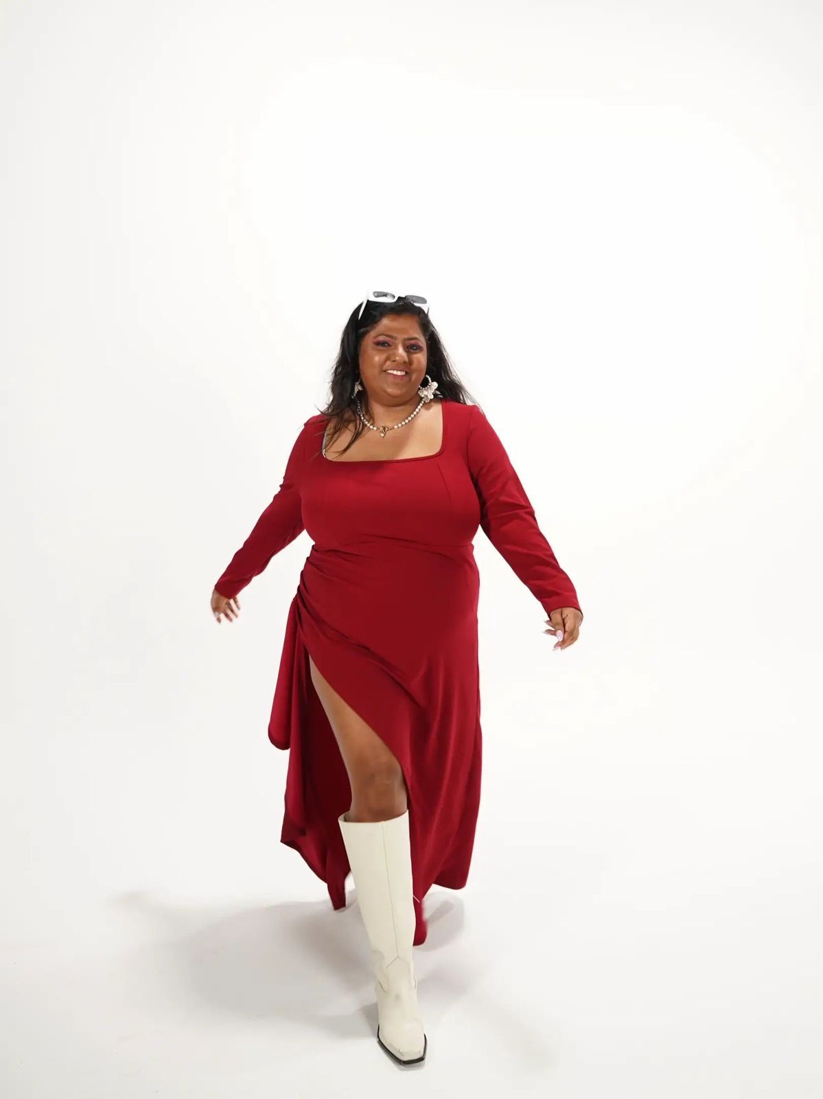 Lakshmi in a red dress mid-stride