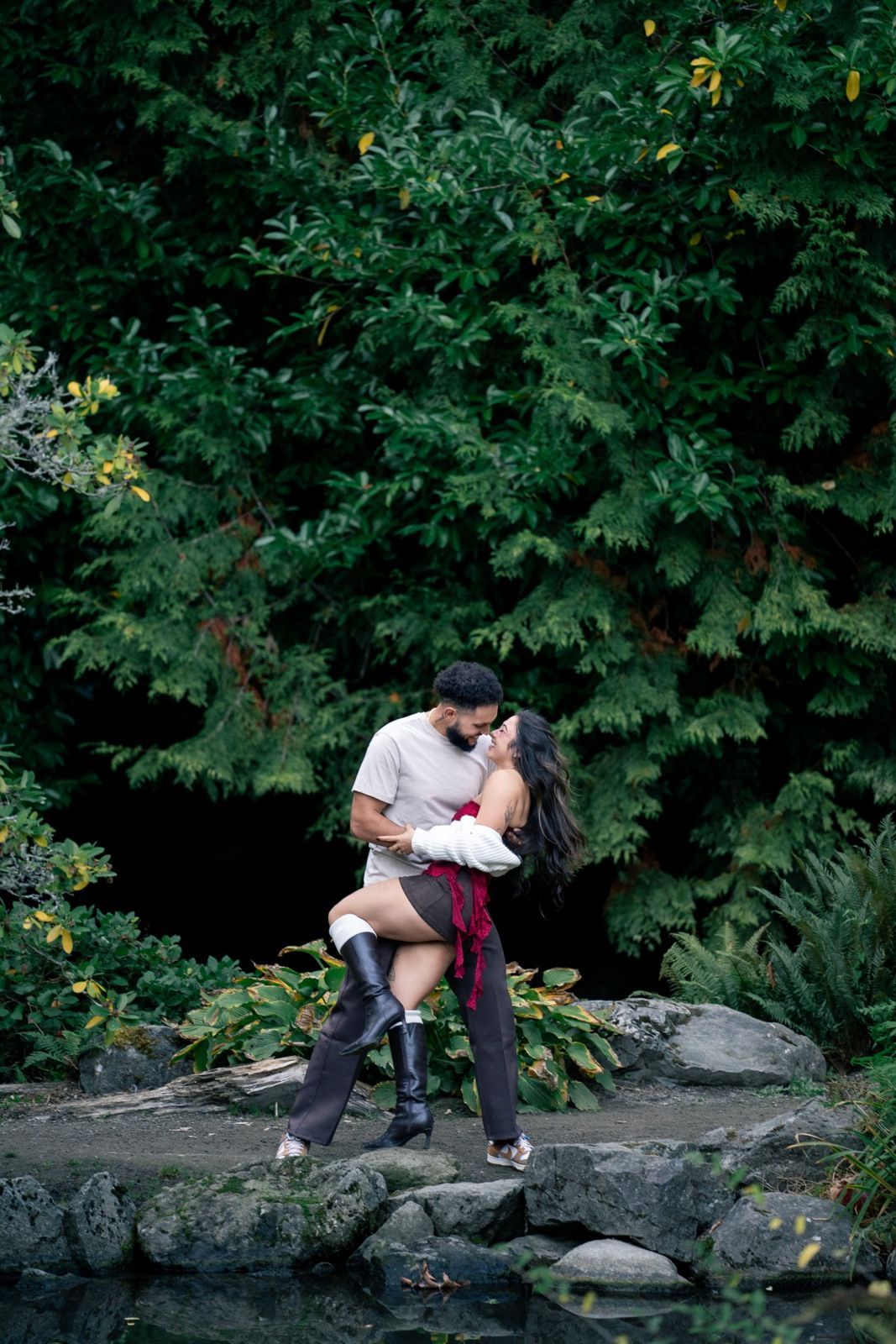 Couple embracing on rocks by a pond