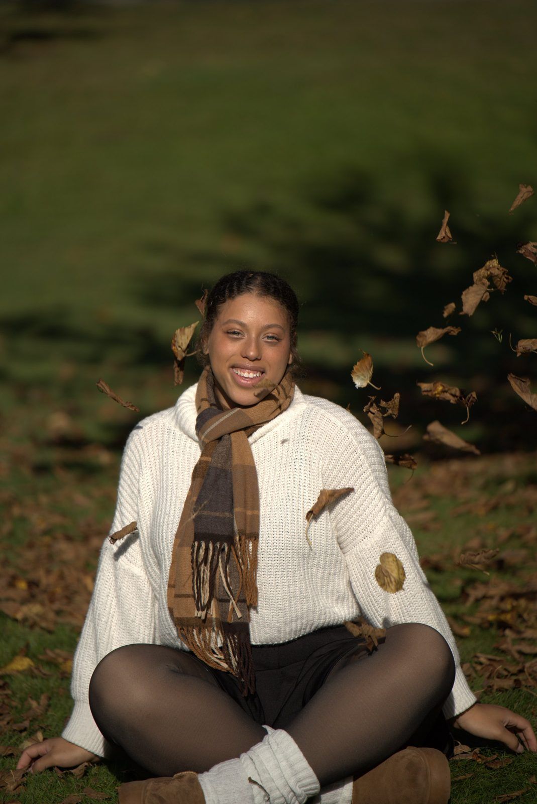 Portrait sitting cross-legged as leaves fall
