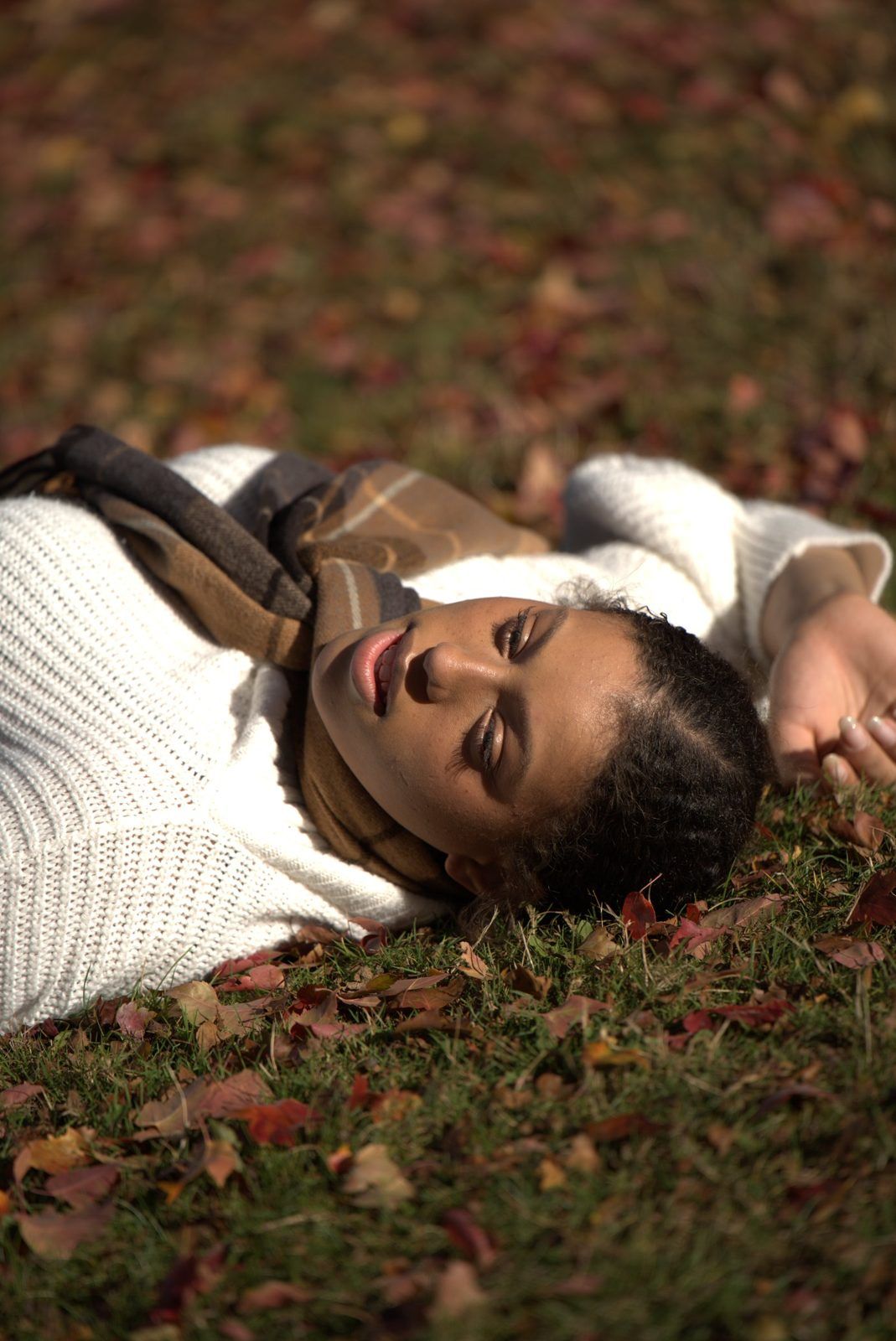 Portrait lying among red autumn leaves
